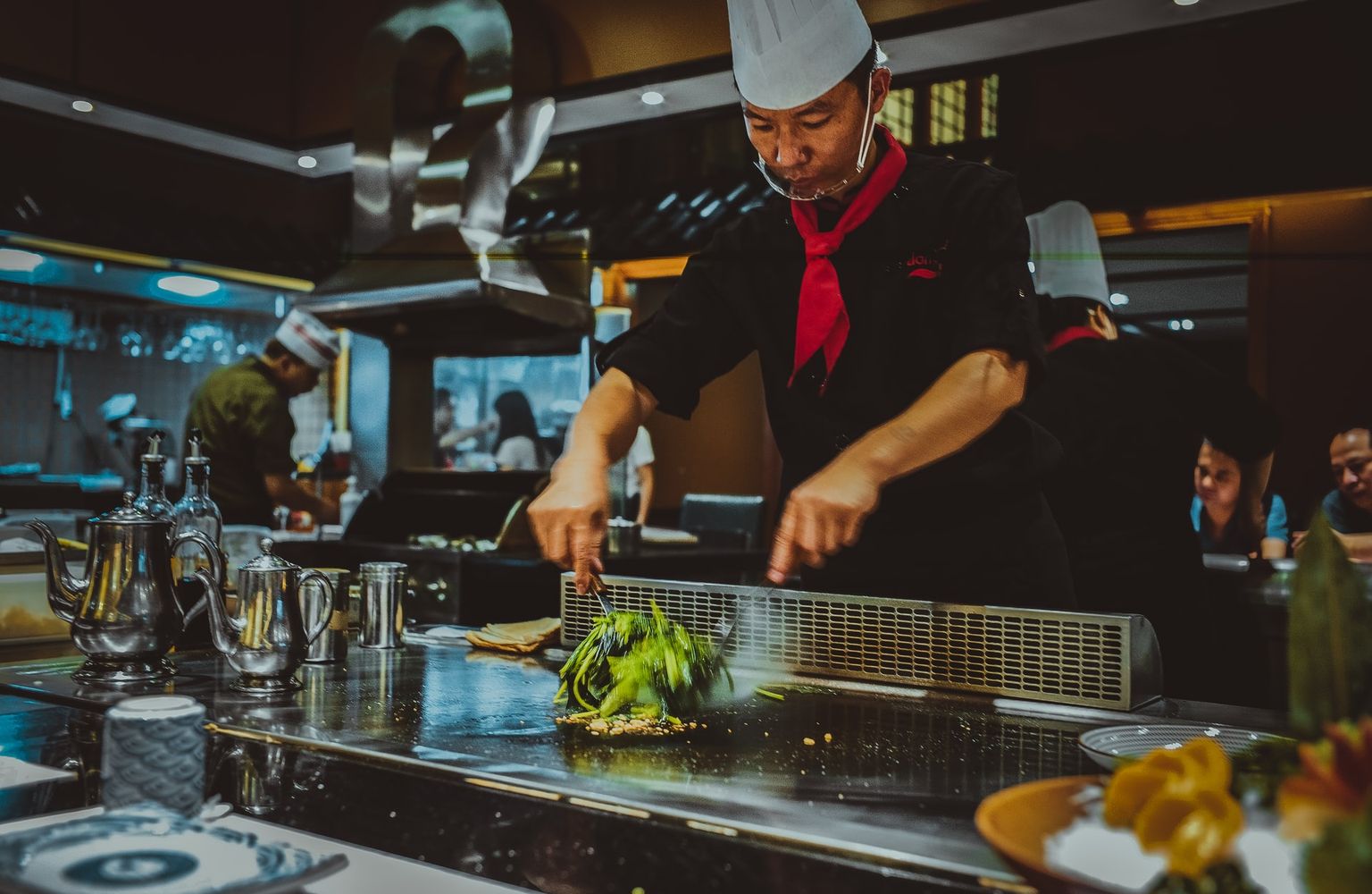 Chef working over hot grill in a busy restaurant